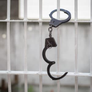 hand cuffs cuffed to a jail cell door